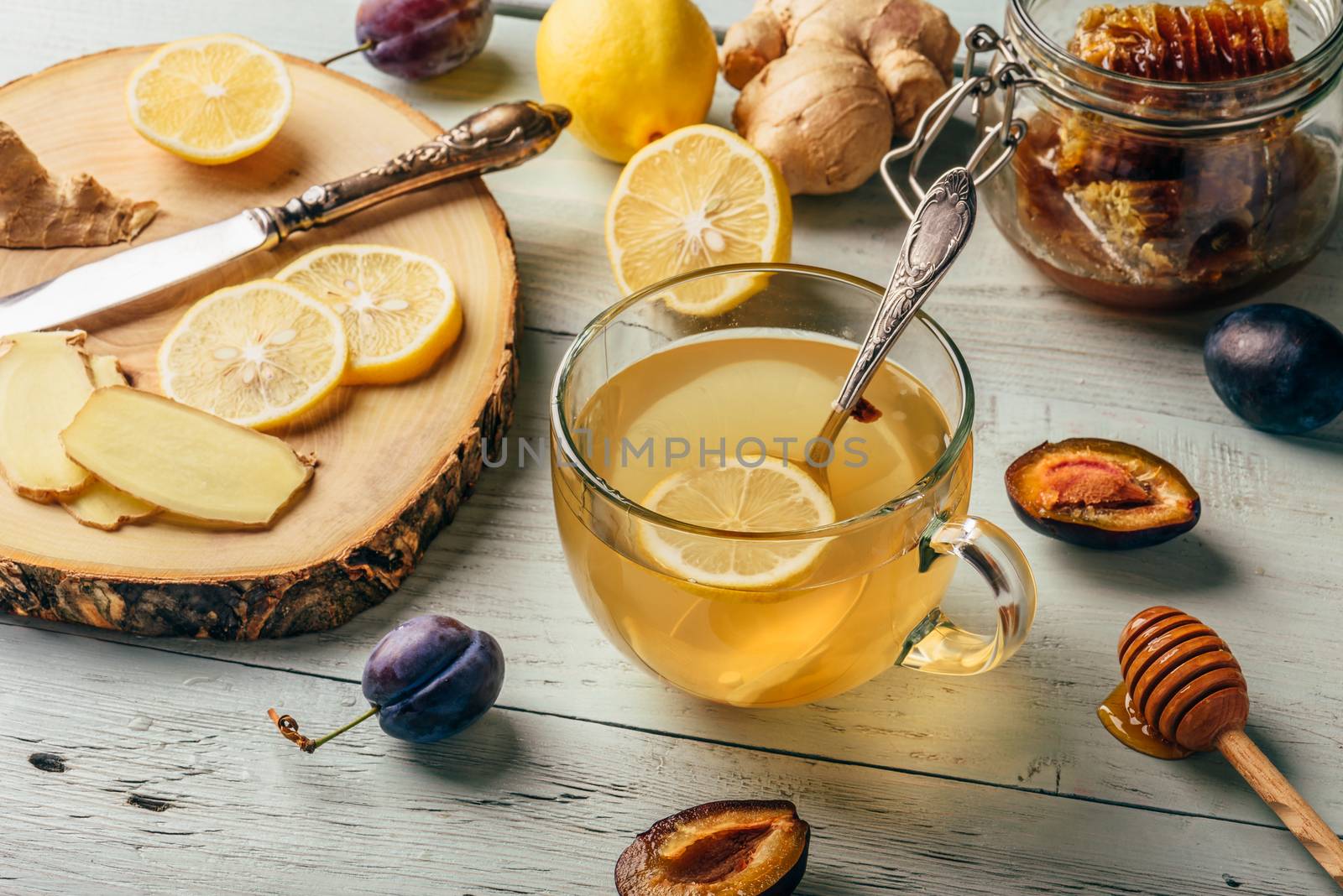 Cup of tea with lemon, honey and ginger over wooden surface