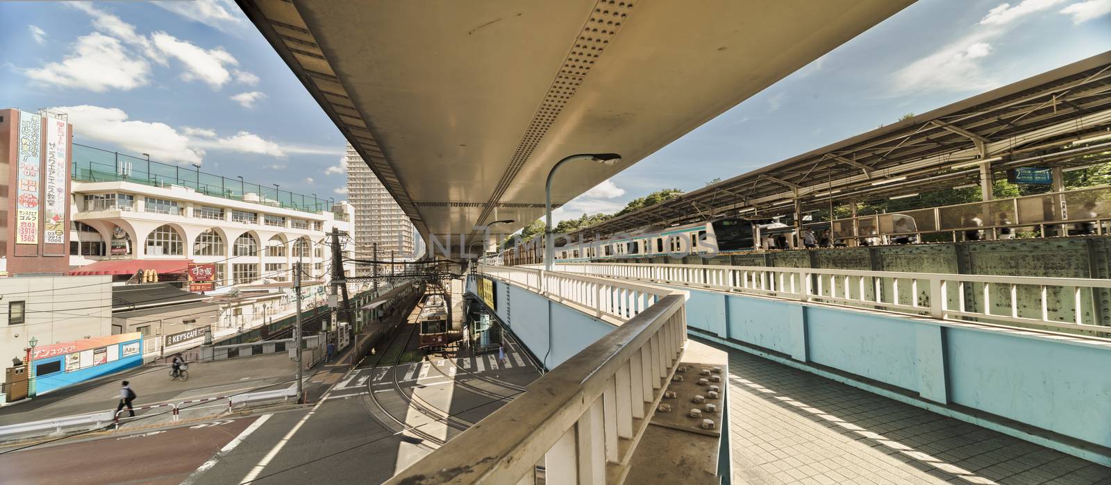 Oji station JR Keihin Tohoku Line in the Kita district, north of Tokyo. The pedestrian walkway spans the intersection of Meiji Avenue where the Ojiekimae station of the Toden Arakawa tram line is famous for its retro style.