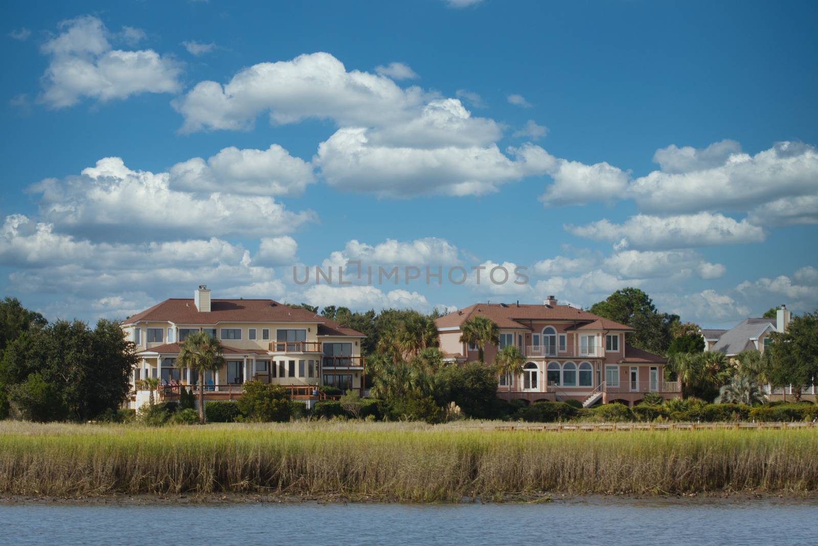 Two massive homes with a marsh view along a salt water channel