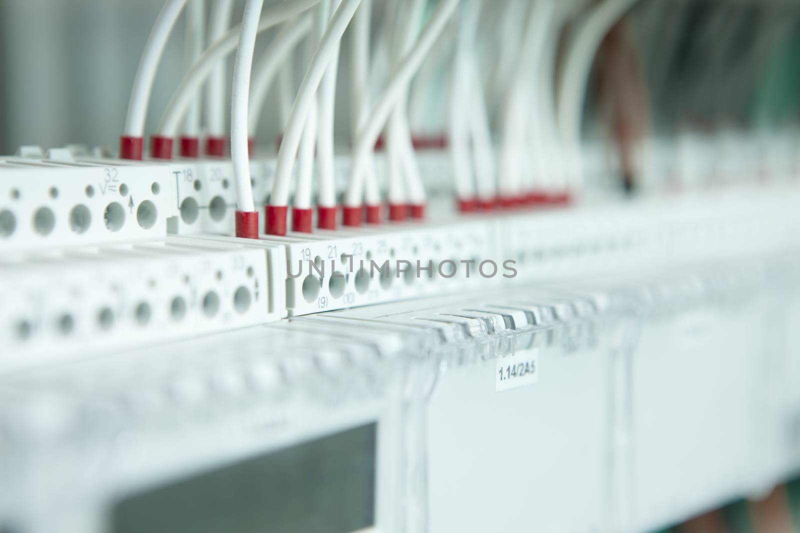 electric working on a clean modern switchboard with white cables