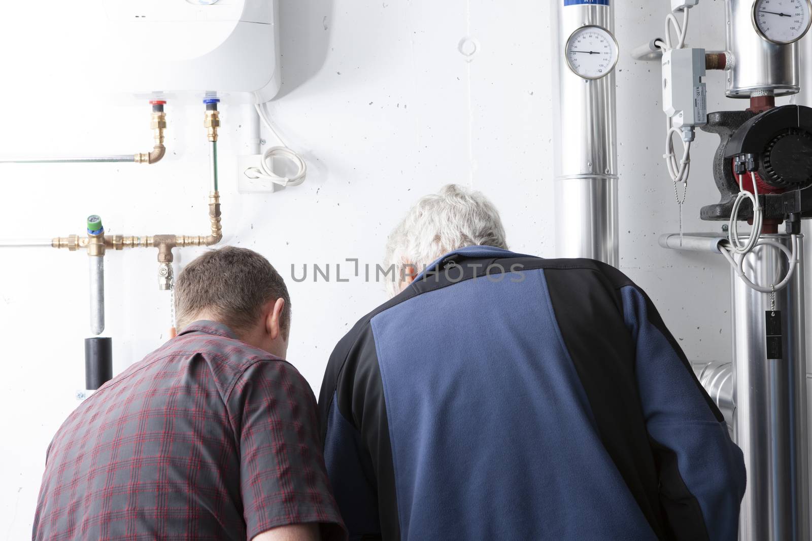 men at work in ac and heating room. Workman from back
