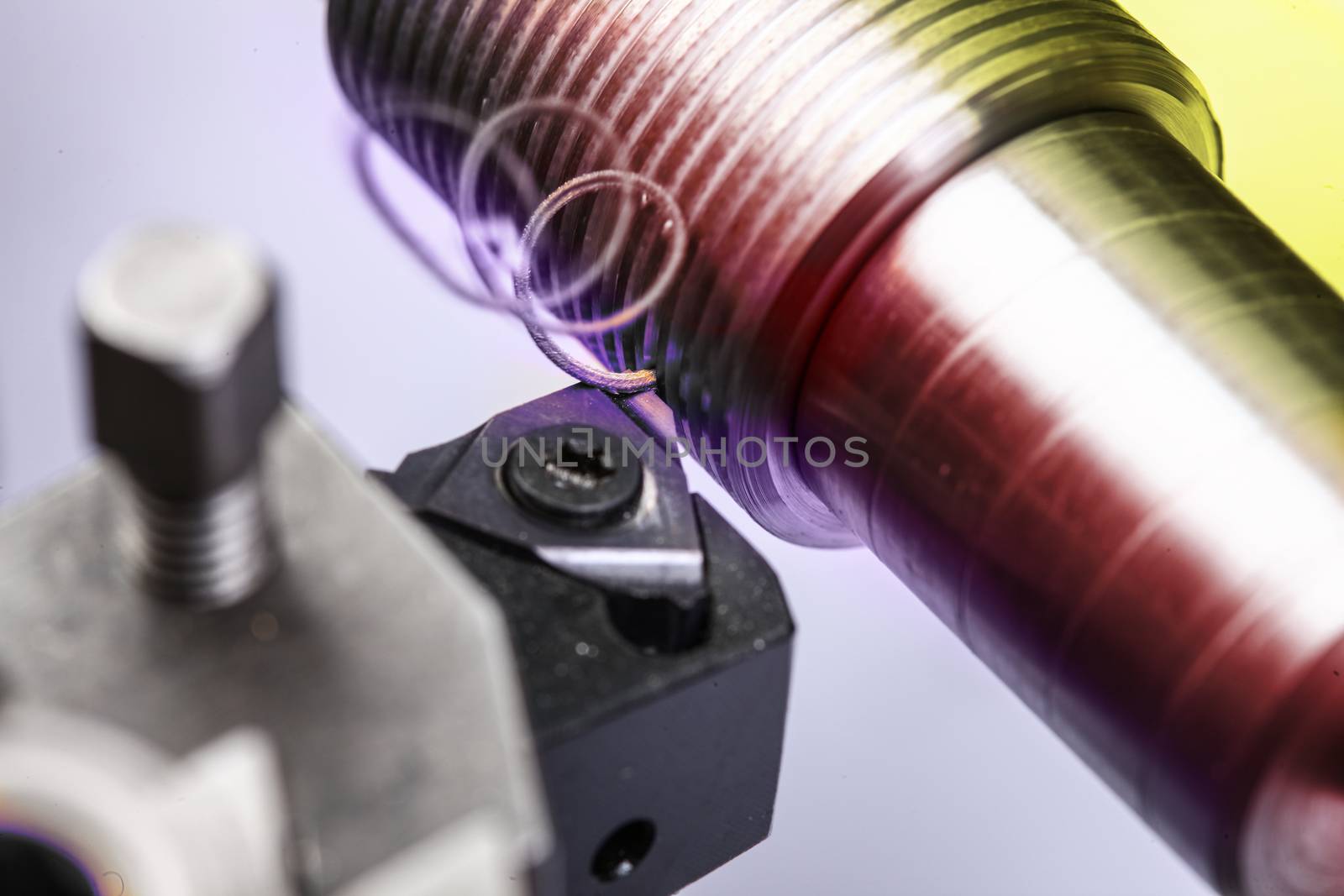 close up of metal cutting on lathe with colored metal