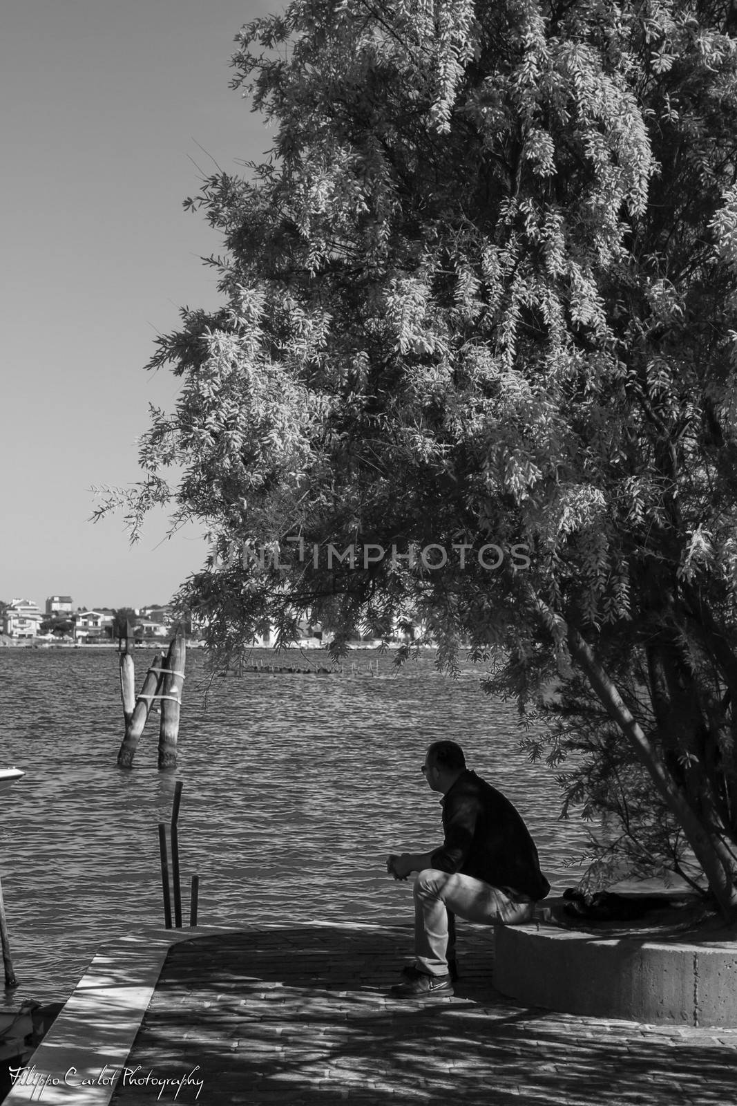 Man sitting watching the sea, image in black and white
