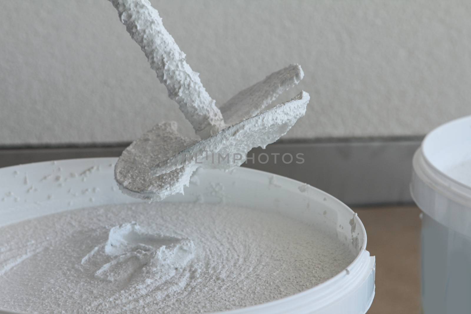 Plasterer stirring plaster in a bucket, White color