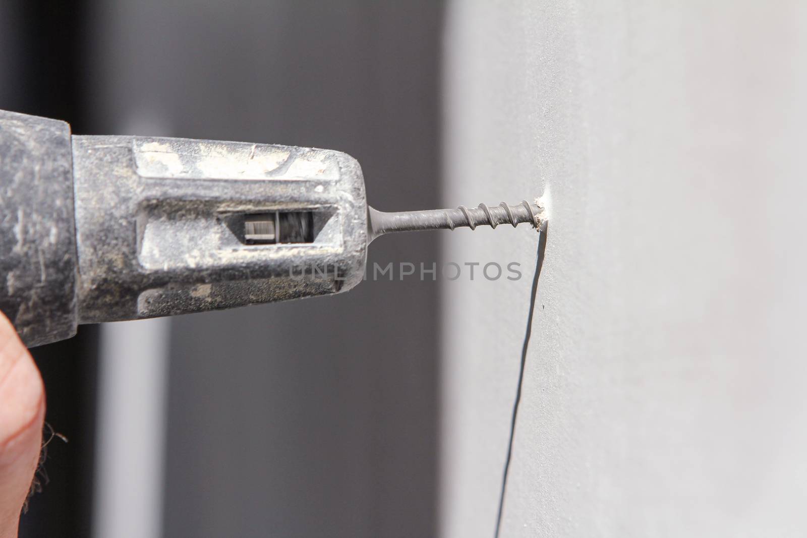 Plasterer screwing sheetrock to a wall, With white copy space