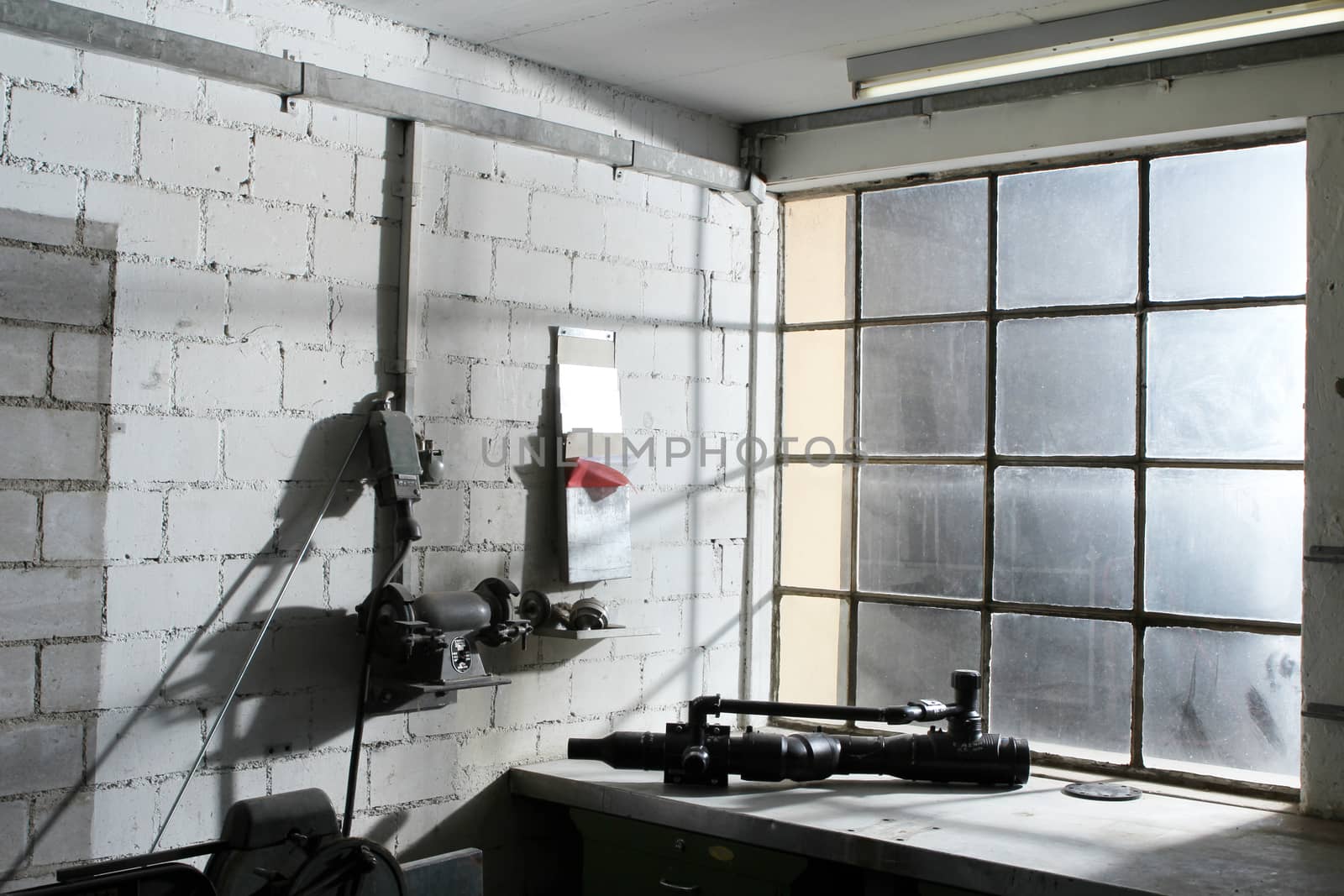 old work space with dirty dusty windows and tools. with lights coming from window