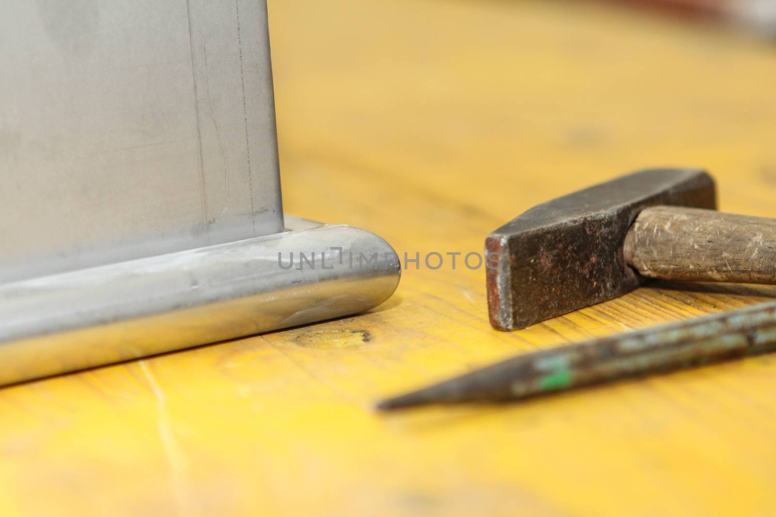 hammer and chisel tools for plumbers with yellow background