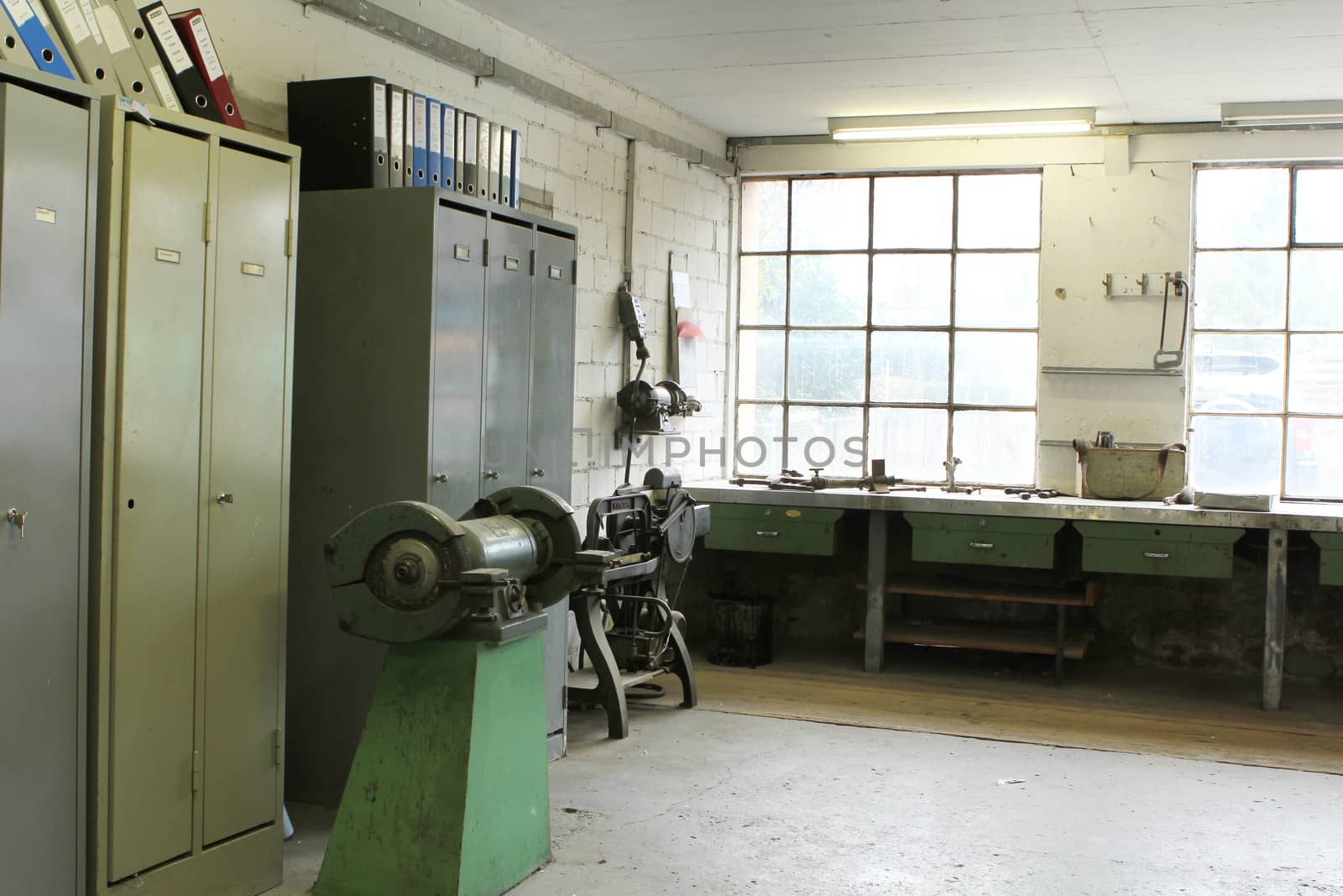 old work space with dirty dusty windows and tools with lights showing through window