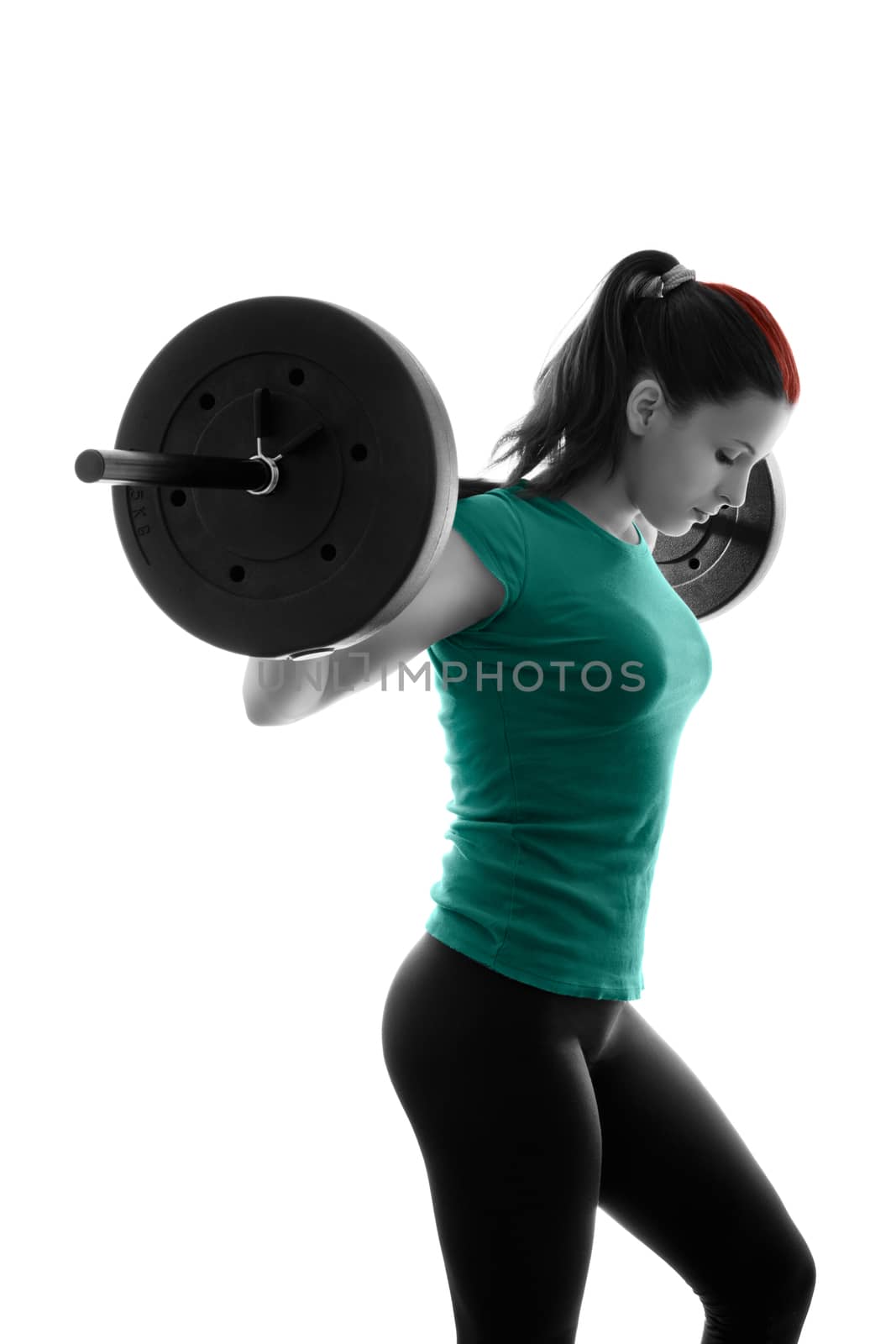 Fit attractive young woman working out with a barbell, looking down, backlit silhouette studio shot isolated on white background. Fitness and healthy lifestyle concept.