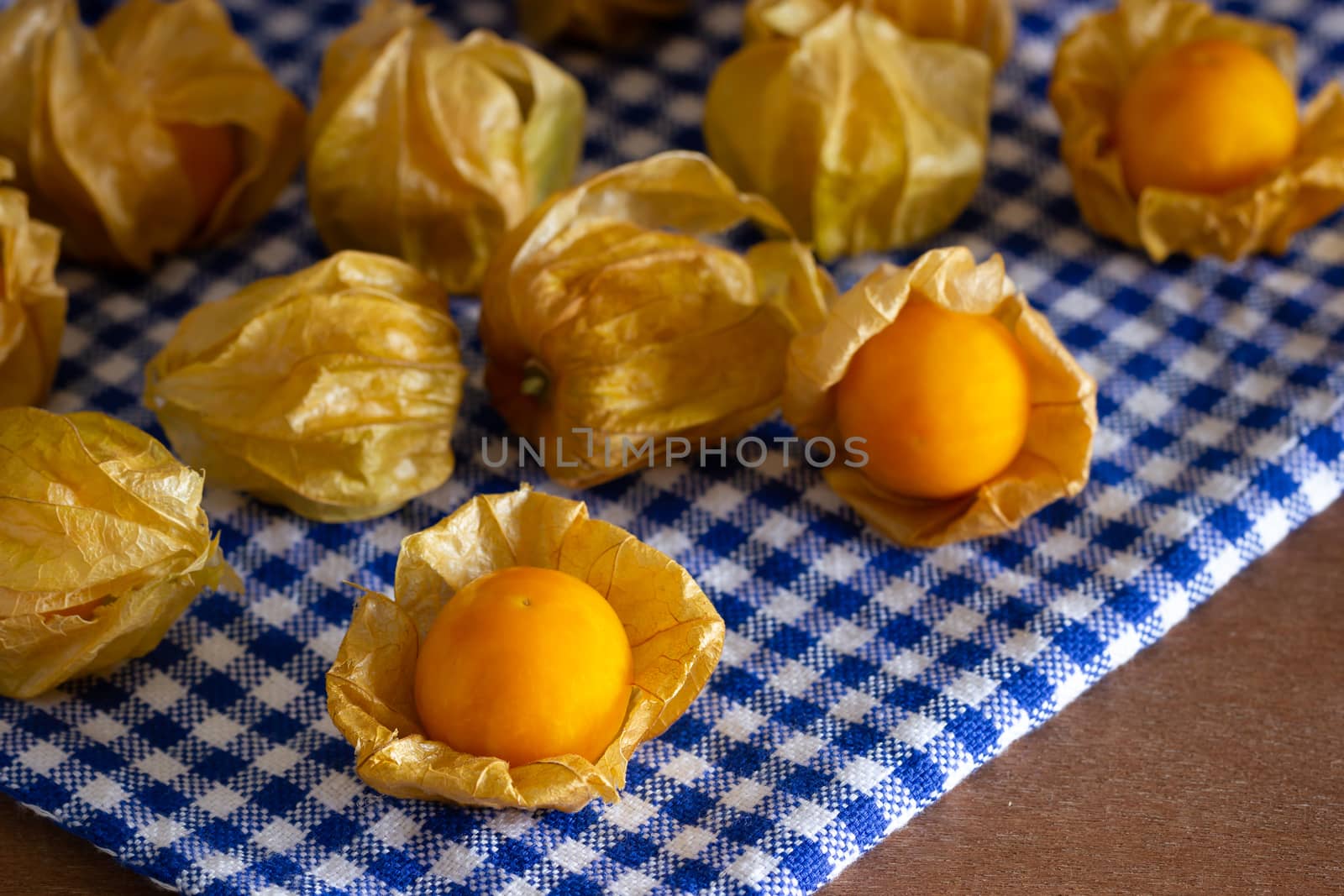 Cape gooseberry on blue tablecloth. Concept of health care. by SaitanSainam