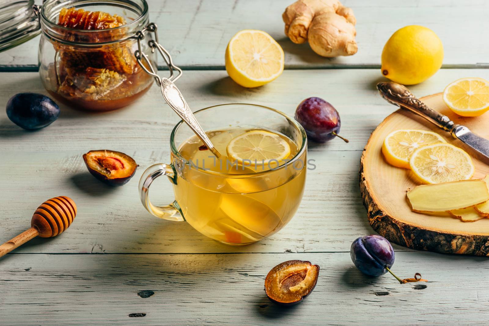 Cup of tea with lemon, honey and ginger over wooden surface