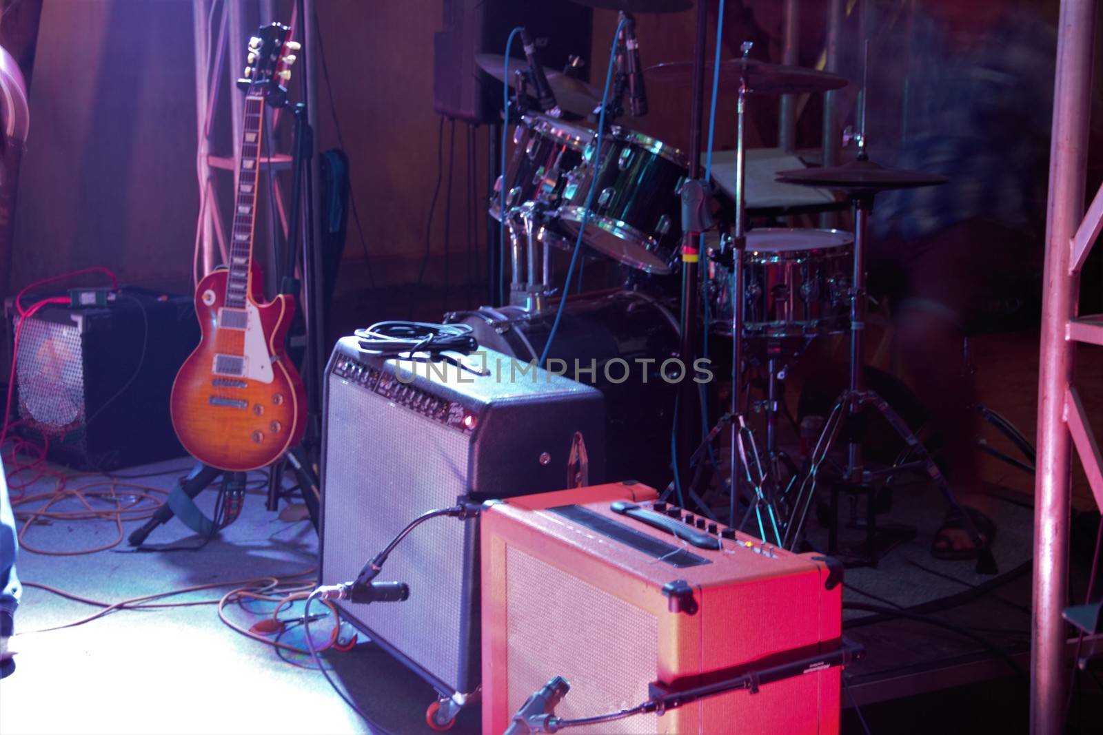 Back line amps, guitar and drums on stage at gig