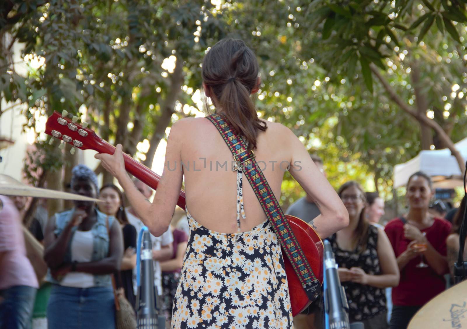 standing behind the stage watching the female vocalist and looking at the crowd.