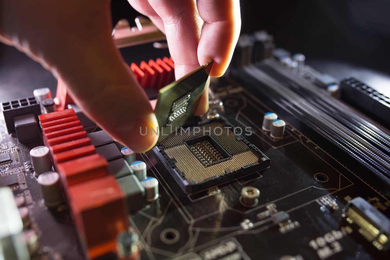 Technician plug in CPU microprocessor to motherboard socket. Workshop background