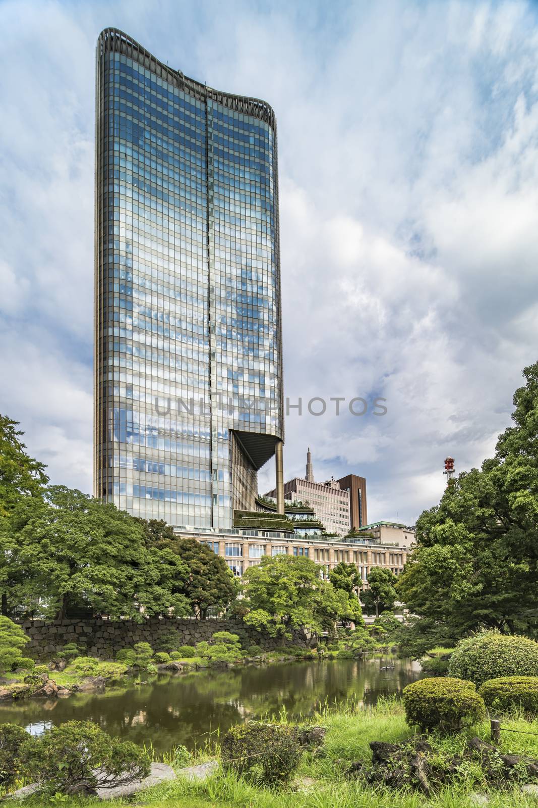 View from the Hibiya public park of the Tokyo Midtown Hibiya building located in the Yurakucho district in Tokyo, Japan.  Completed in March 2018, the project includes office, commercial, and dining and entertainment facilities. The building’s concave glass exterior facing Hibiya Park produces noticeable solar glare onto the streets immediately to the south of the building echoing one of the design flaws of London’s 20 Fenchurch Street skyscraper.