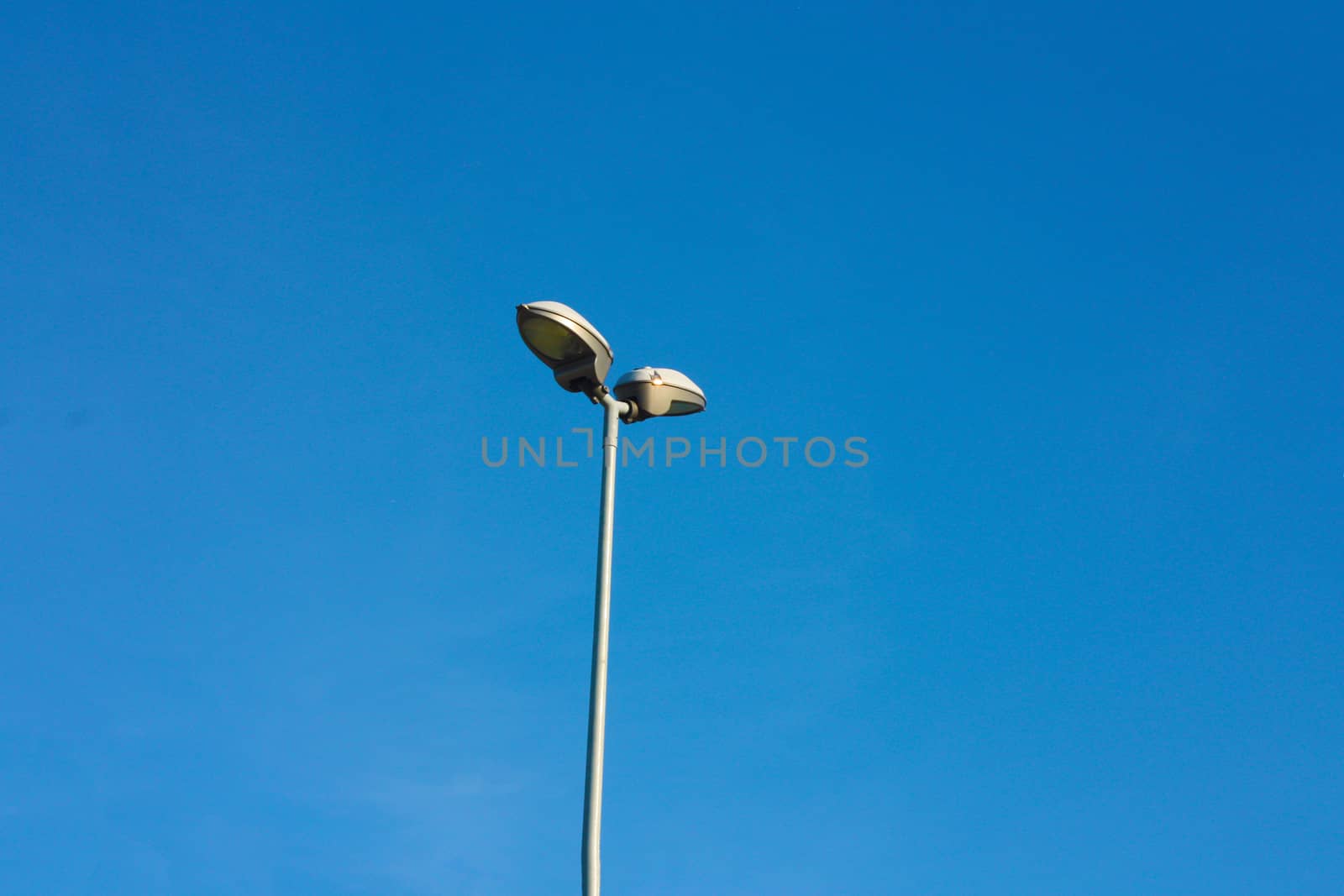 slim and lonely lamppost in contrast against the clear blue sky by alessiapenny90