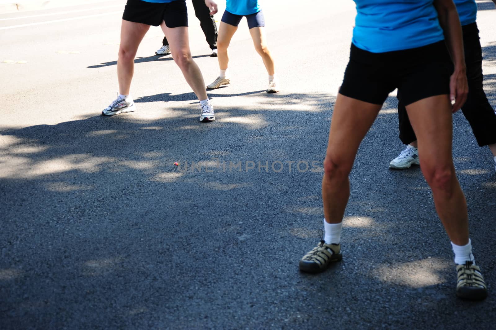 Exercise fitness class performing on the street outside.