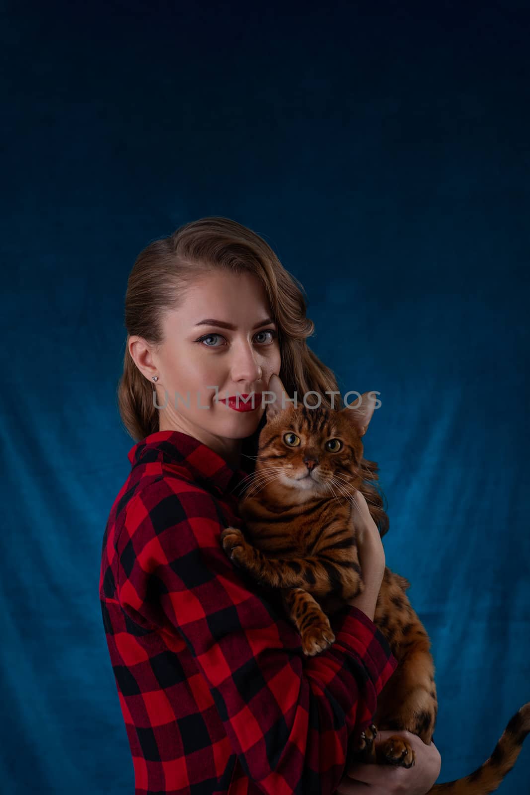 Fashion photo of pretty girl with bengal cat on hands. Bengal ca by alexsdriver