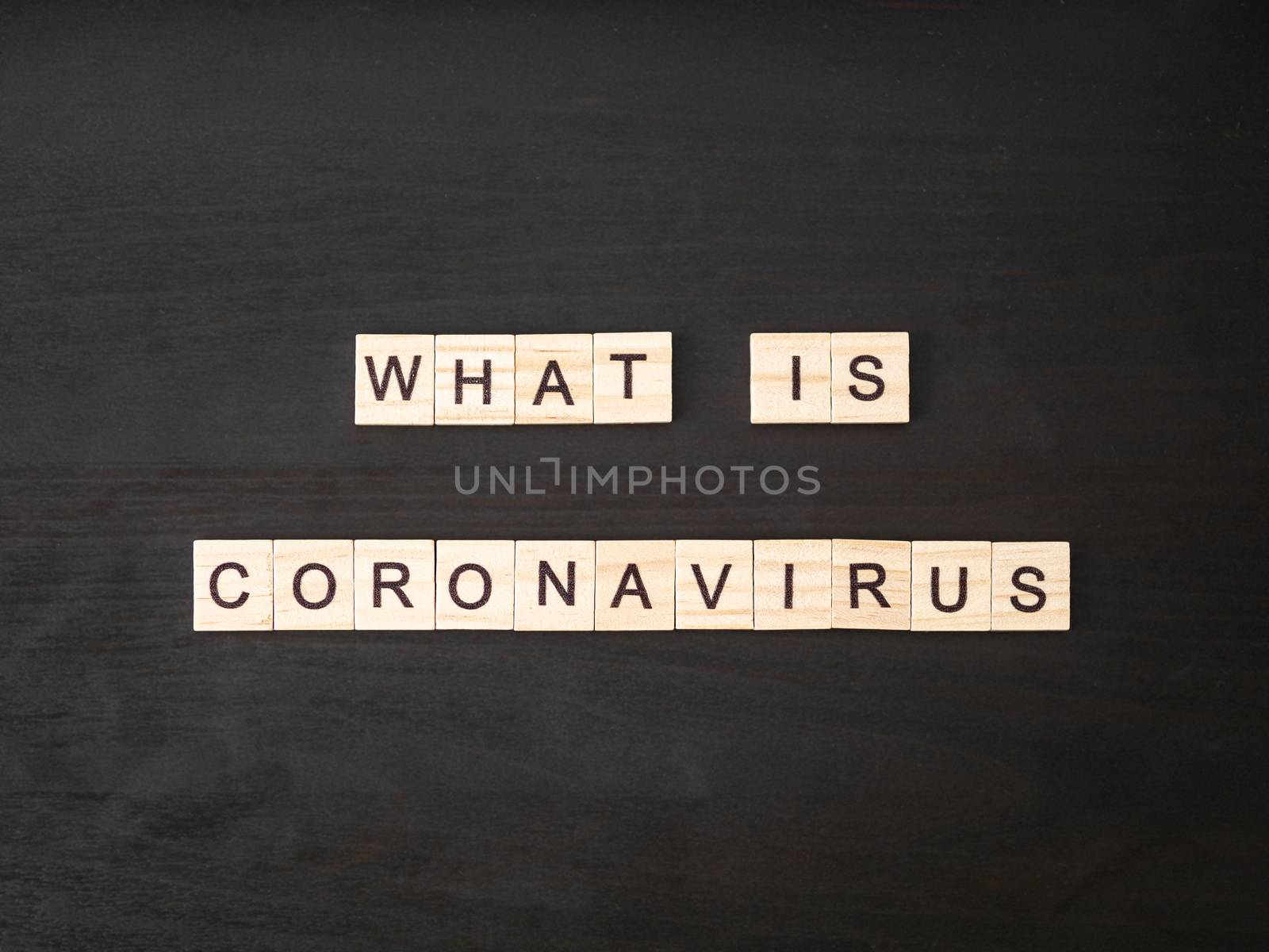 what is coronavirus words made of wood block. What is coronavirus text on dramatic atmosphere black wooden table. Coronavirus concept top view.