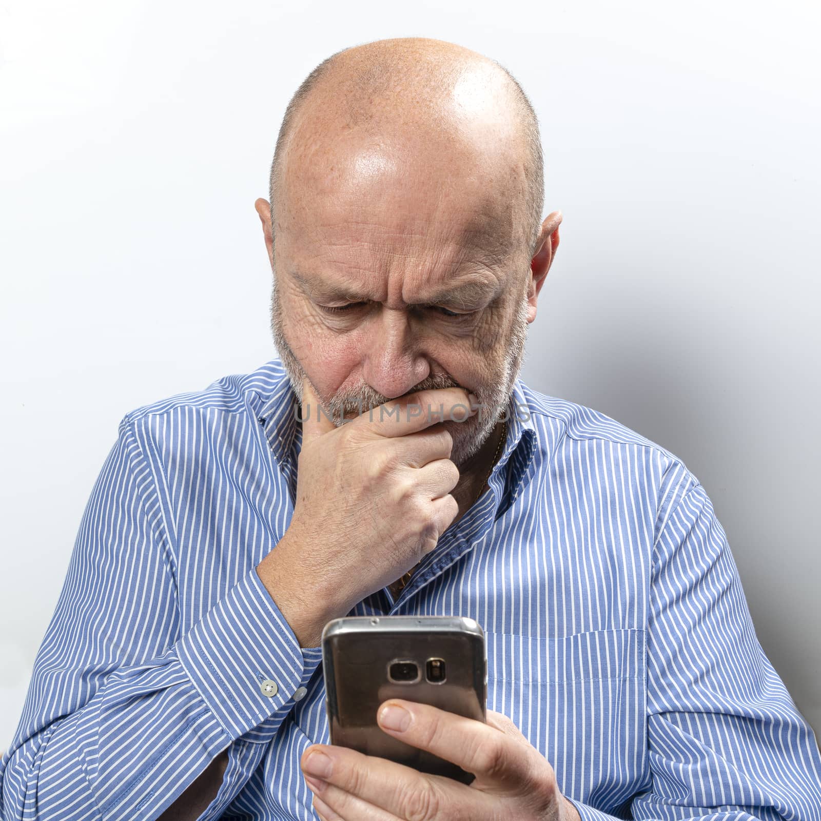 A middle-aged man worried while talking on a cell phone