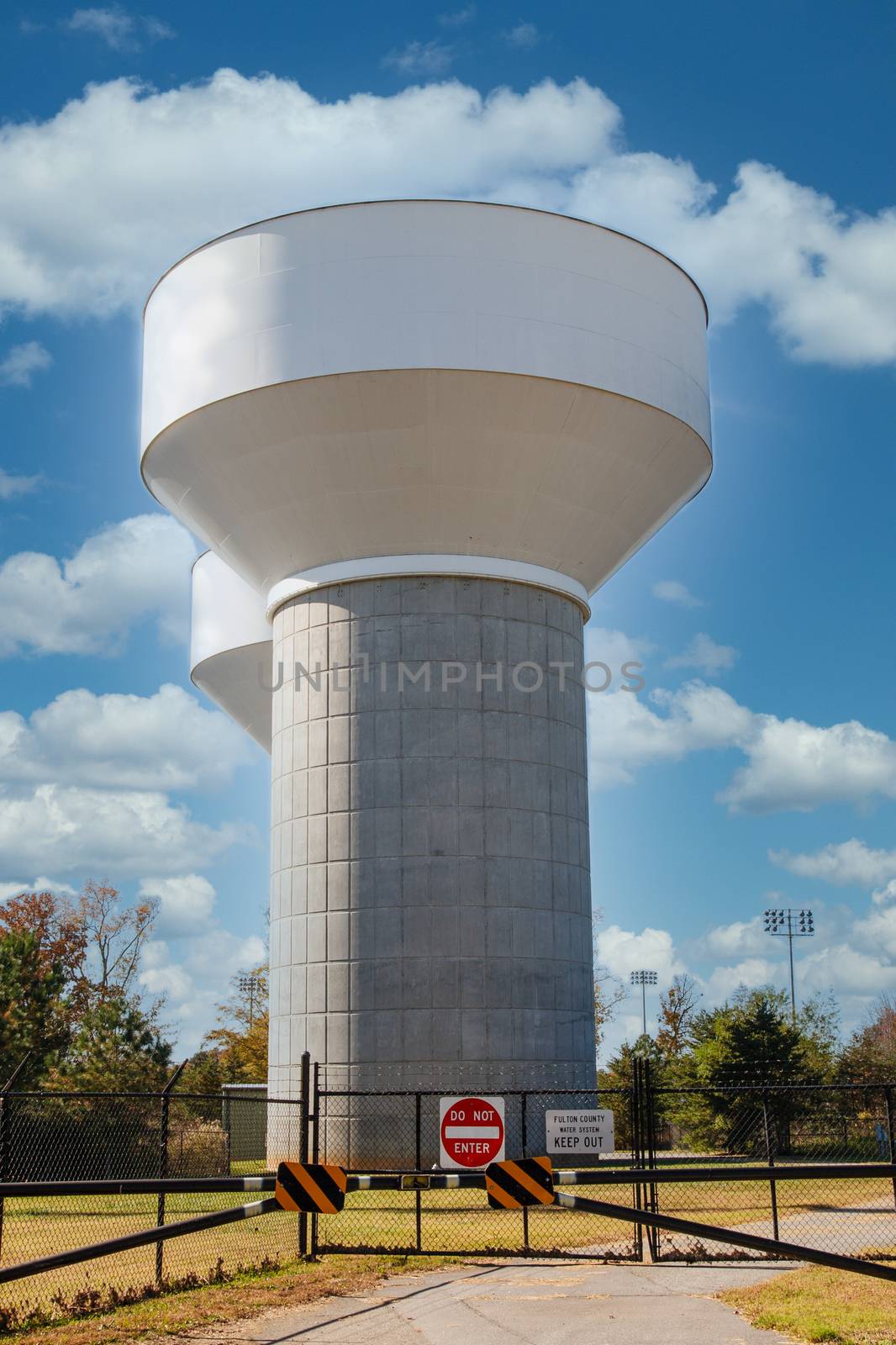 Two modern water towers behind black chain link fence
