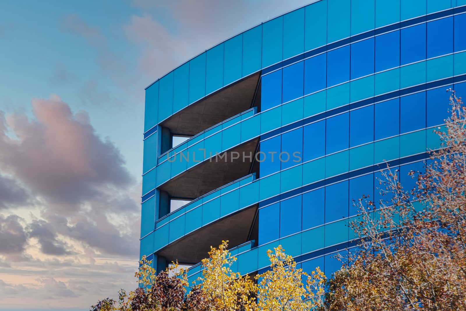 Curved Blue Glass Building at Dusk by dbvirago