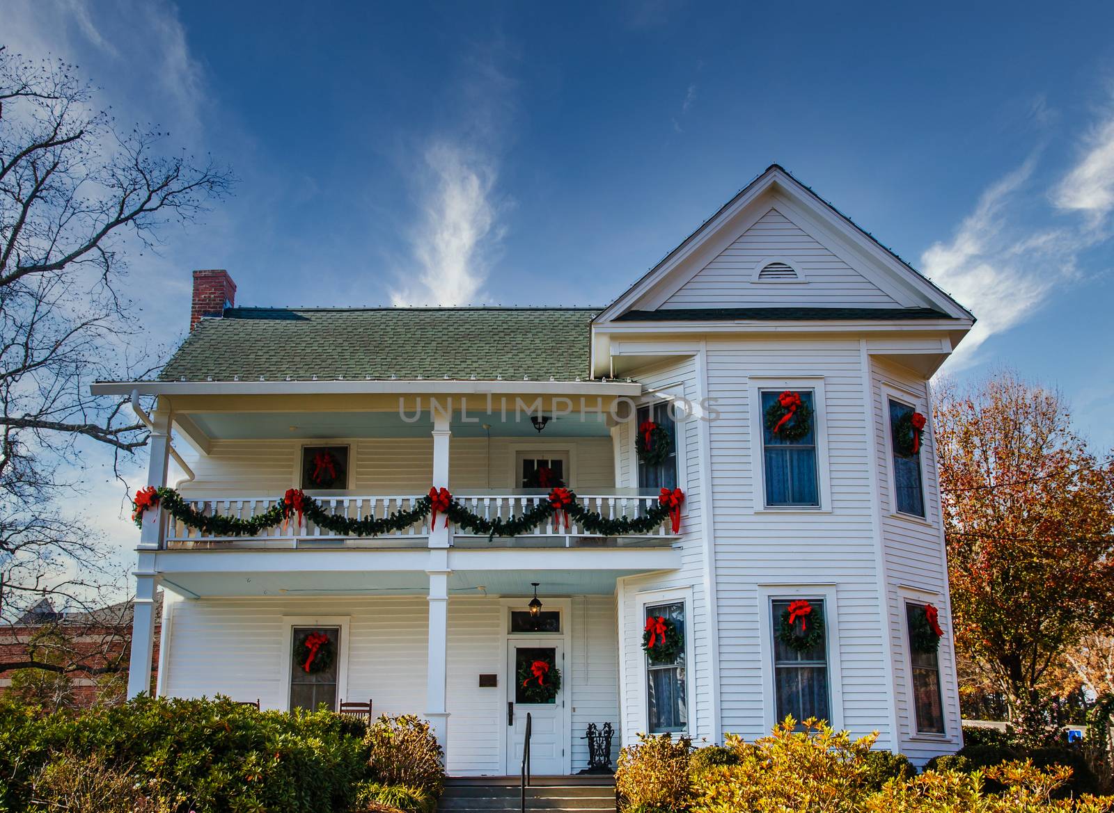 A traditional white two-story farm house decorated for Christmas