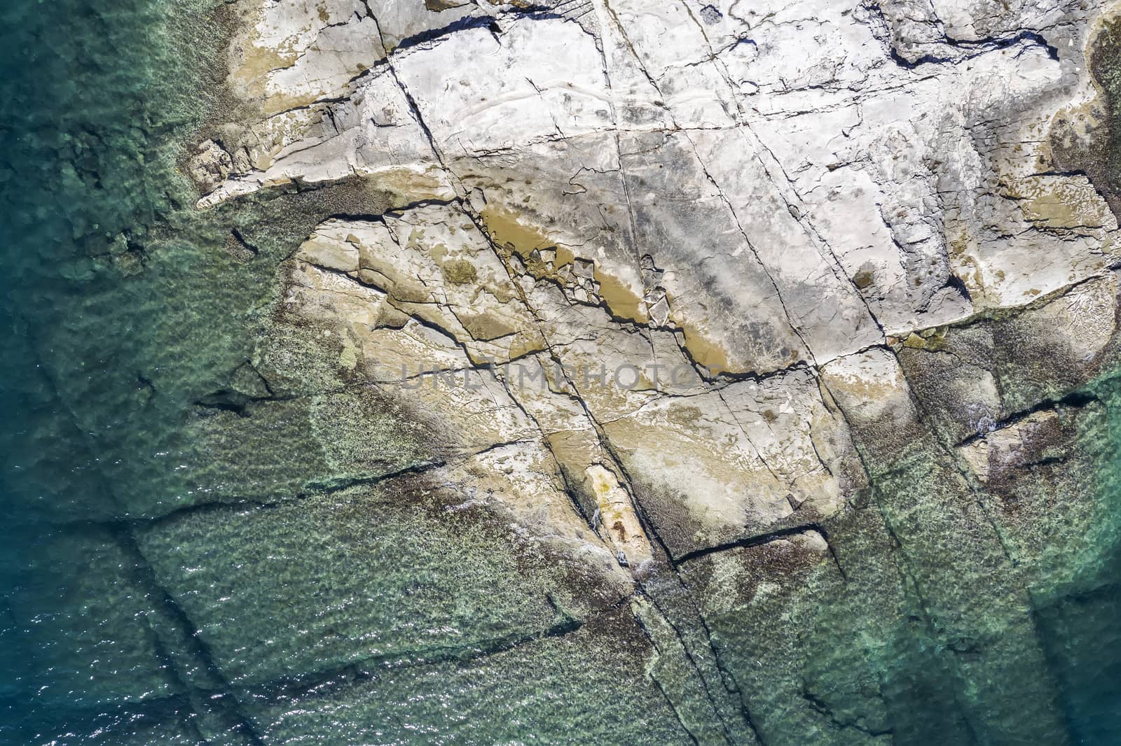 An aerial view of the beach with flat rocky cliffs  by sewer12