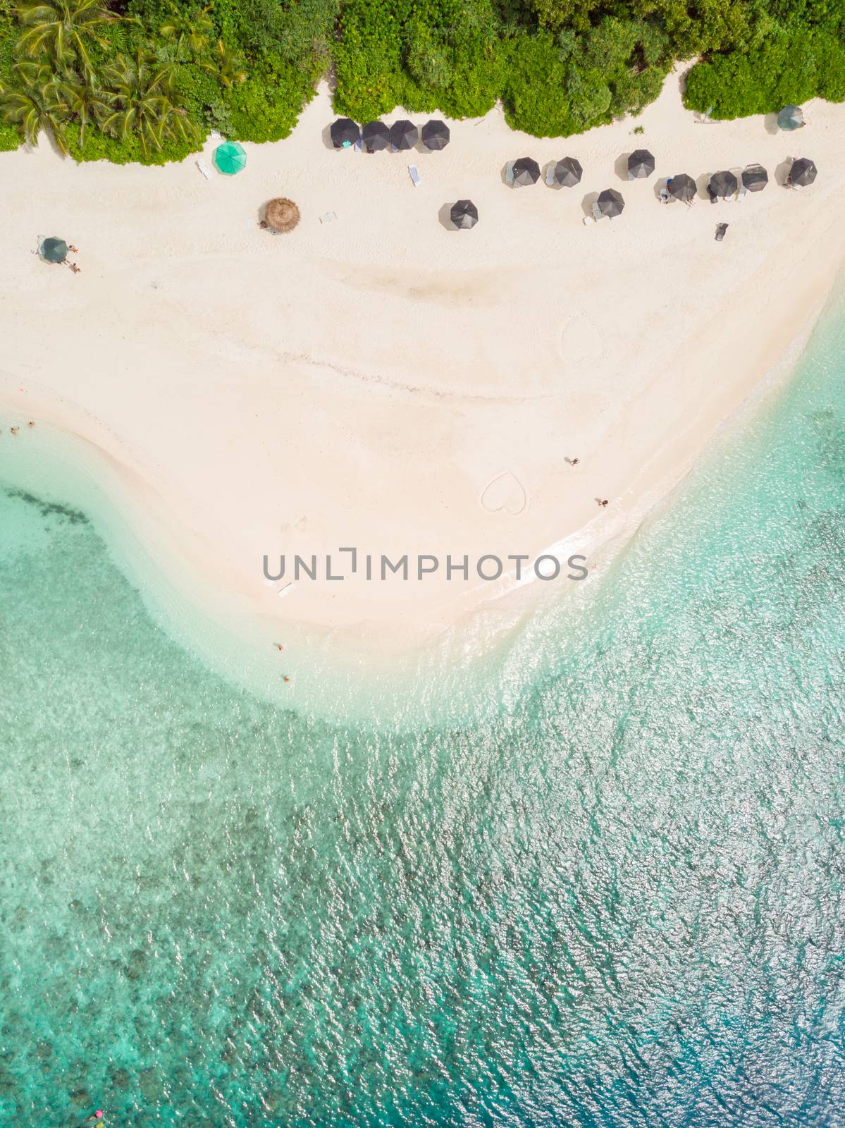 Aerial drone view of picture perfect beach and turquoise lagoon on small tropical island on Maldives.