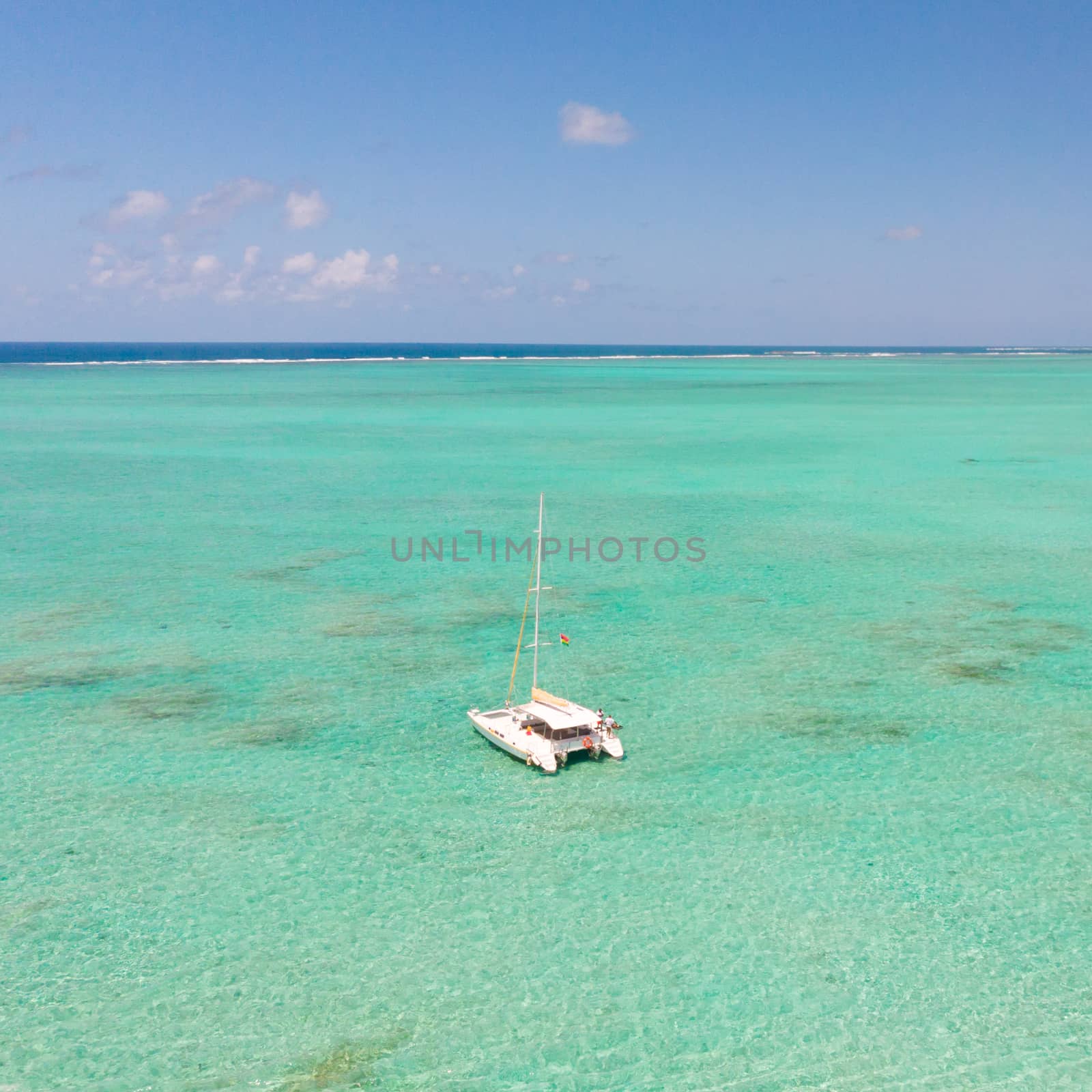 Catamaran sailing boat in turquoise sea lagoon on tropial Mauritius island. Aerial, drone view. by kasto