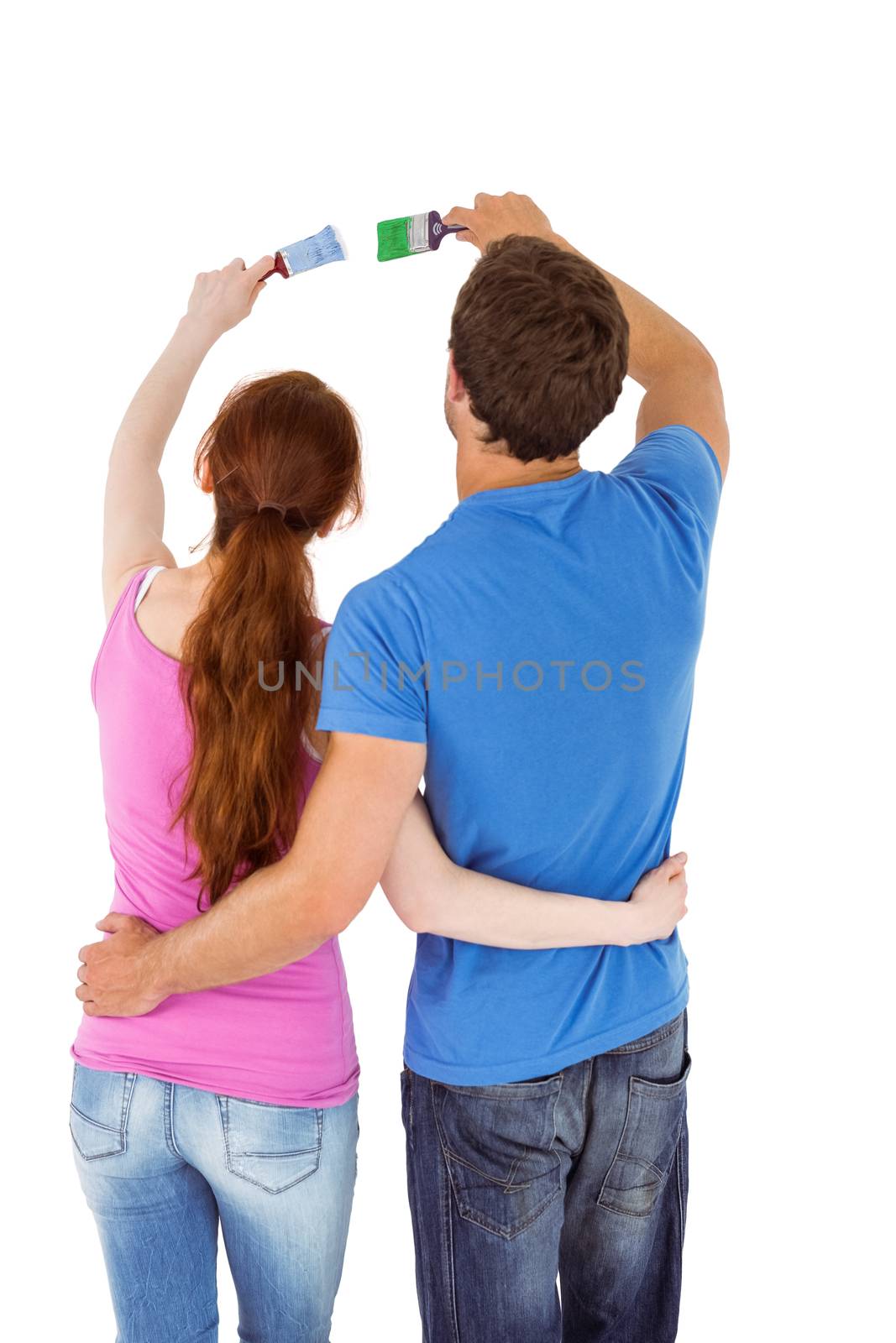 Couple both holding paint brushes on white background