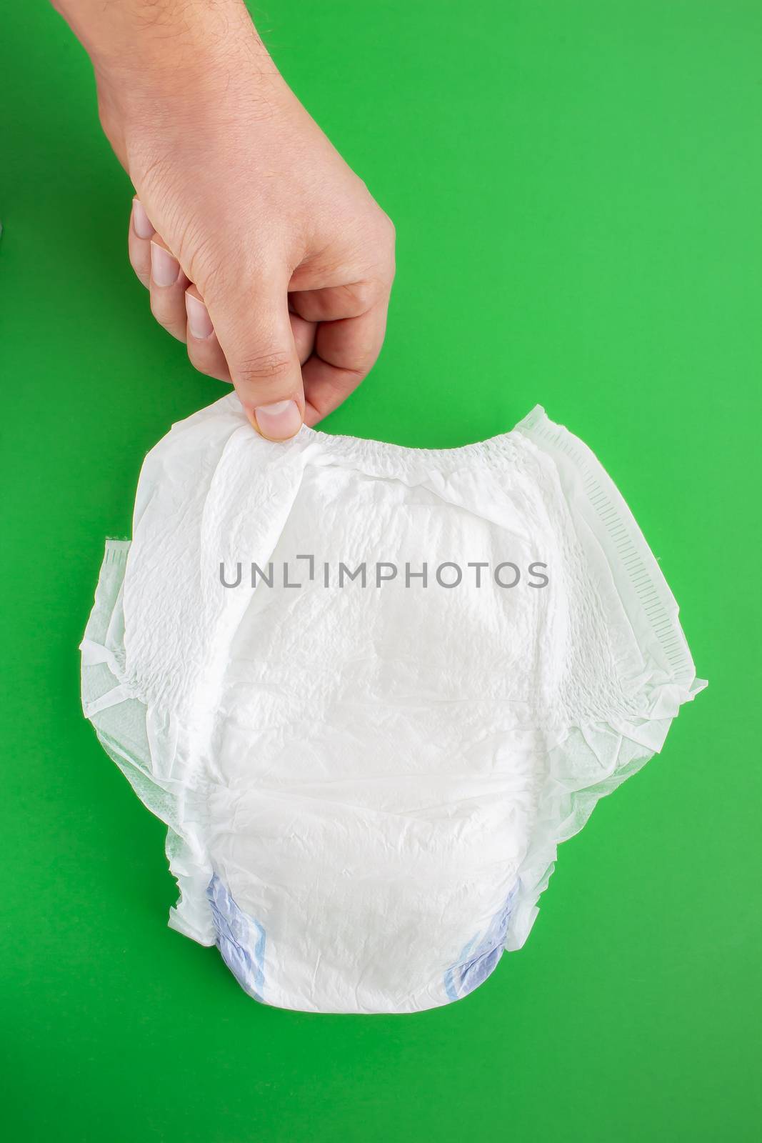 A person holding a diaper on a green background