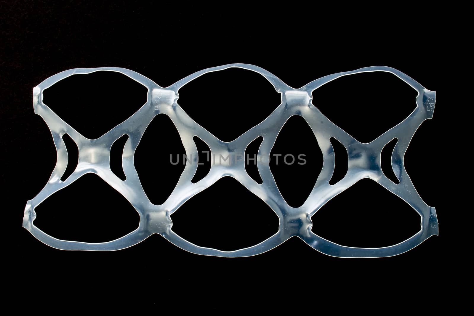 Isolated six pack rings or six pack yokes, connected plastic rings used in multi-packs of beverage on a black background