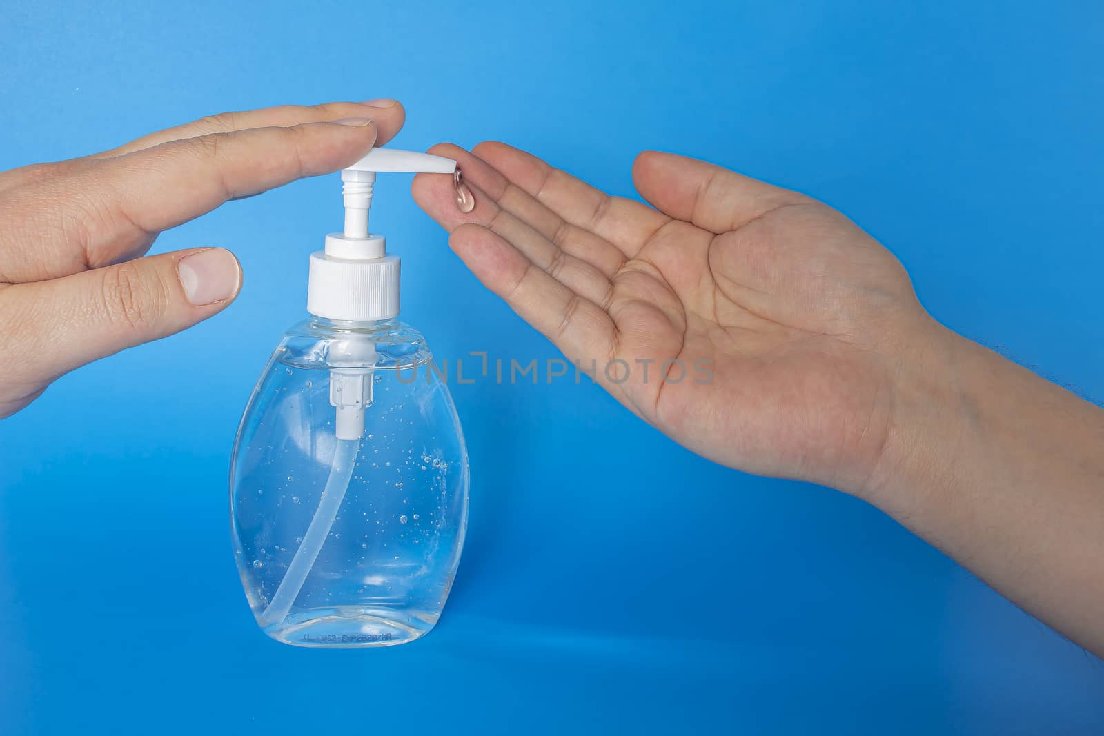 A person putting hand sanitizer isolated on a blue background
