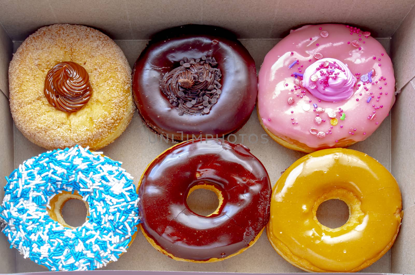 Top view Inside of a Tim Hortons six donuts box, with a: Dulce de Leche, Chocolate Truffle, Strawberry, Vanilla Dip, Chocolate, Maple Dip Donut. by oasisamuel