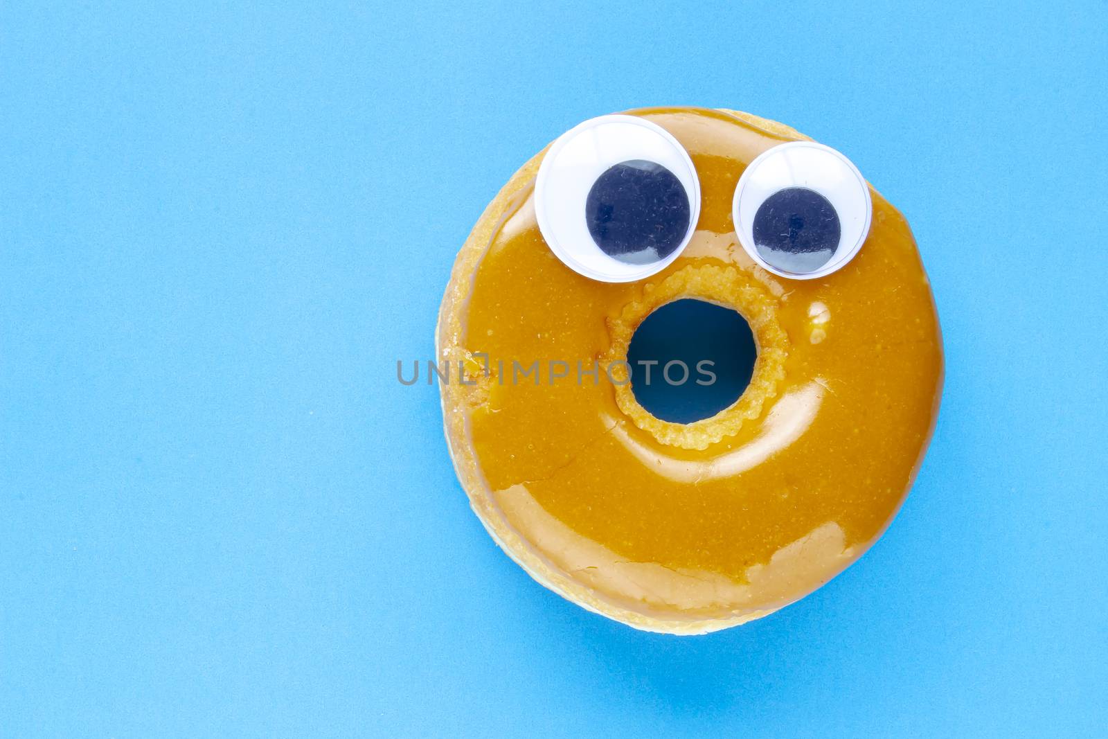 A Canadian Maple Dip Donut with Black Wiggle Googly Eyeballs on a blue background by oasisamuel