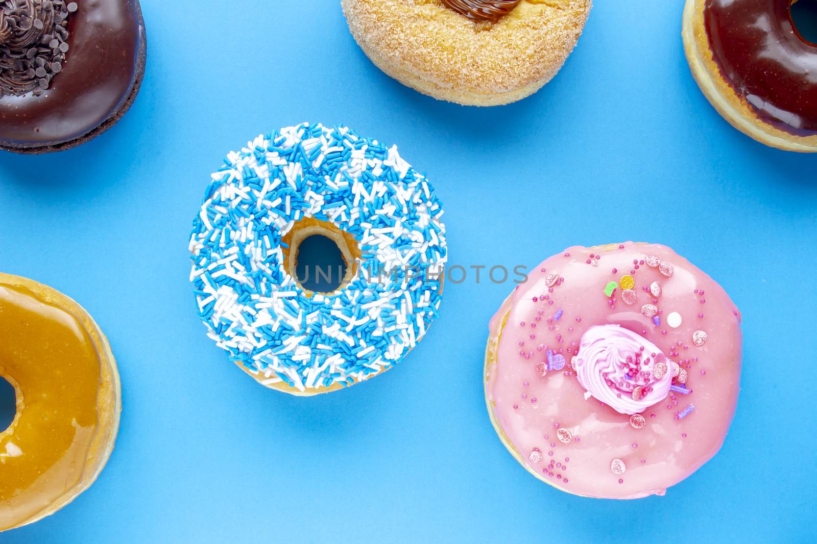 Colorful Donuts on a blue background by oasisamuel
