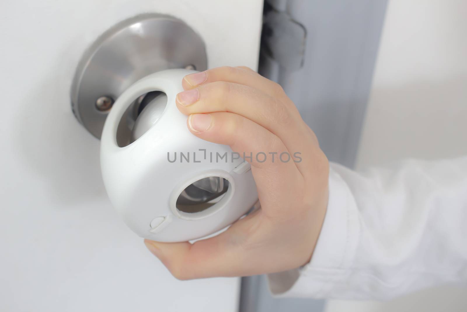 Child Proof Door Knob Covers over doorknob with a kid's hand trying to open the door