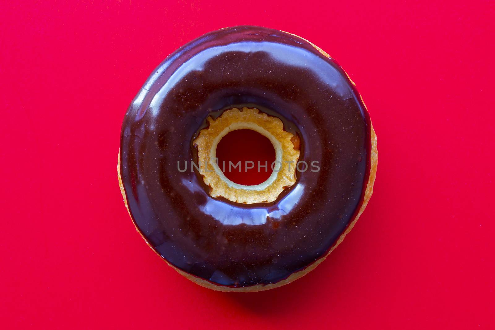 A Chocolate Dip Donut on a red background