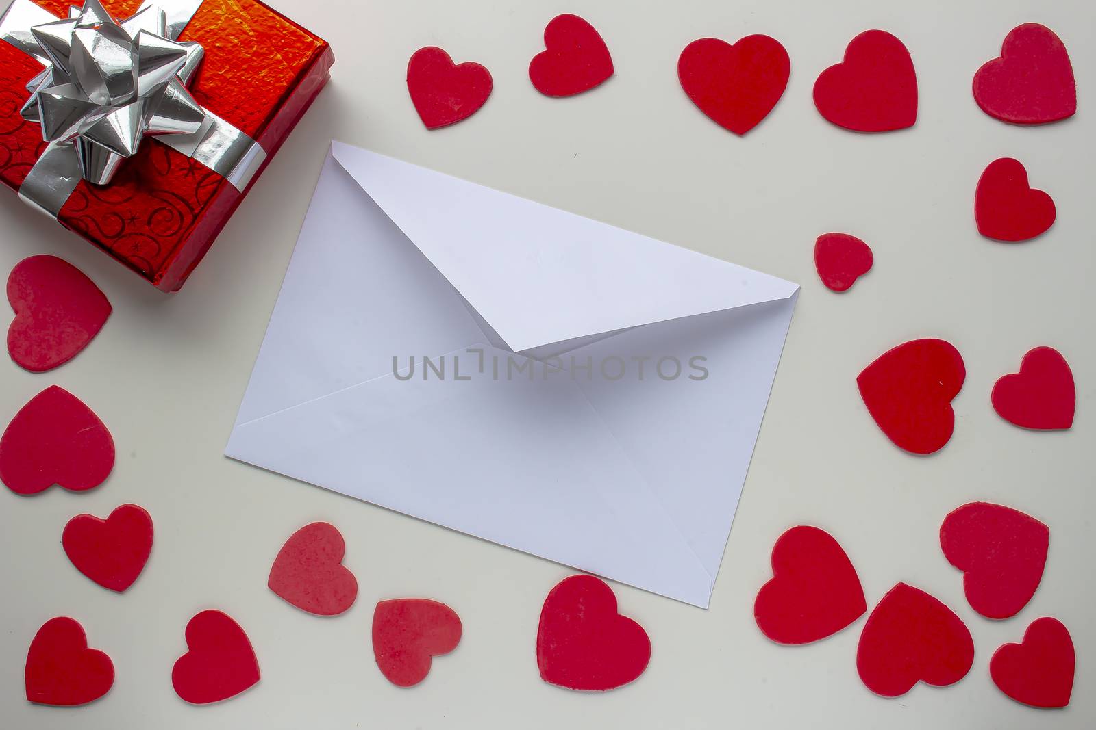 paper letter envelope with a present box gift with hearts around by oasisamuel