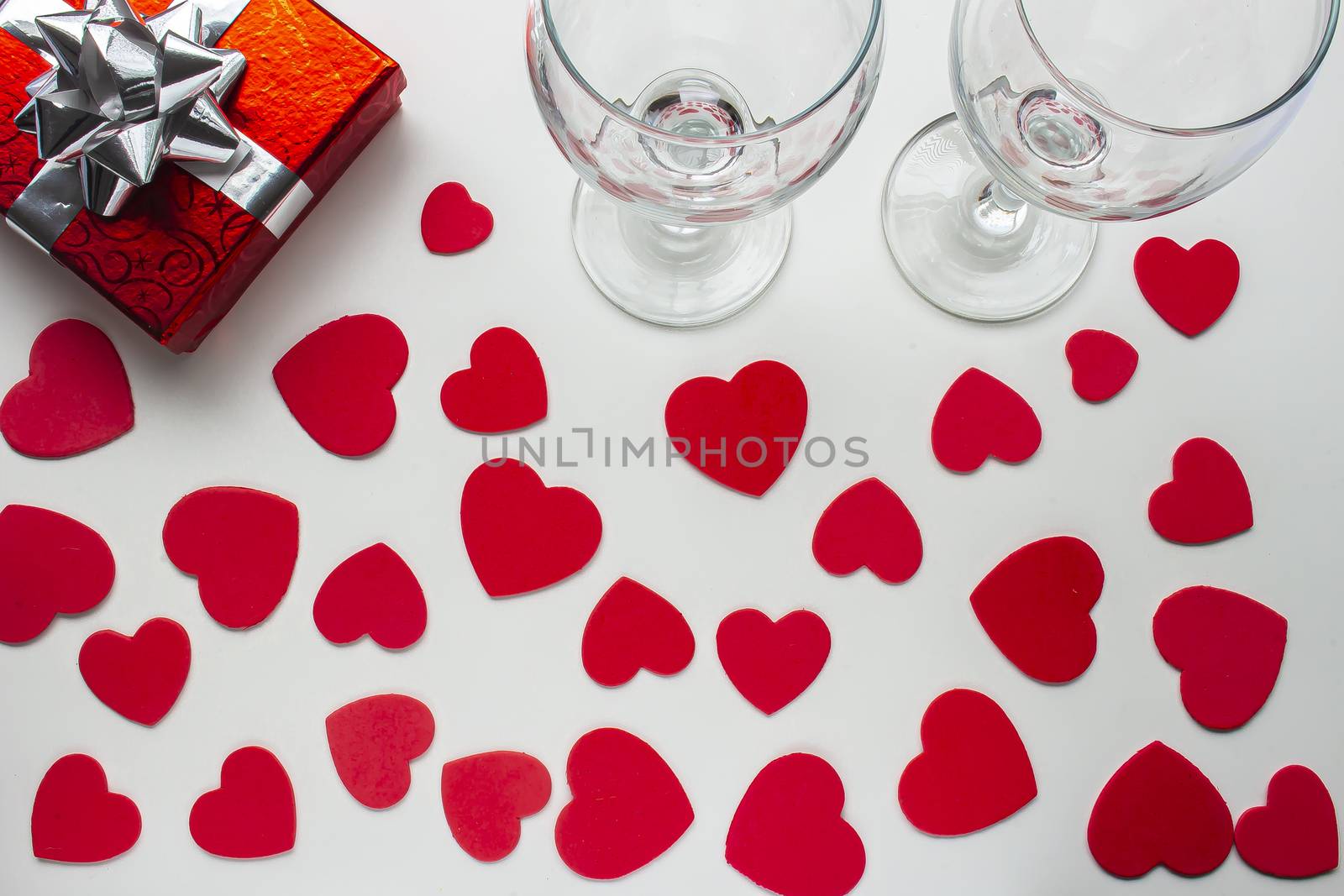 A couple of empty cups with a red present box with hearts around by oasisamuel