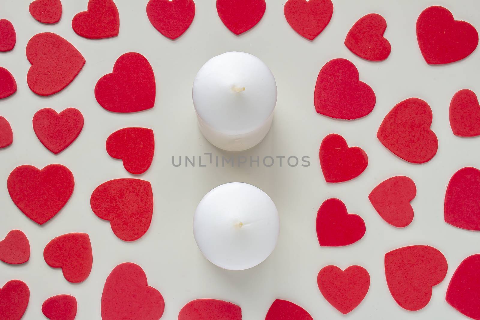 A couple of candles with red hearts around