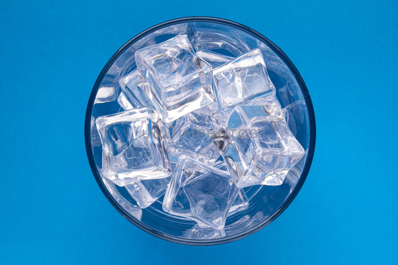 Regular scotch glass with crystal Ice cubes on a blue background
