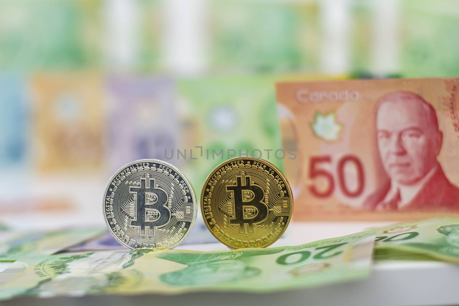 Bitcoins with canadian bills on the background by oasisamuel