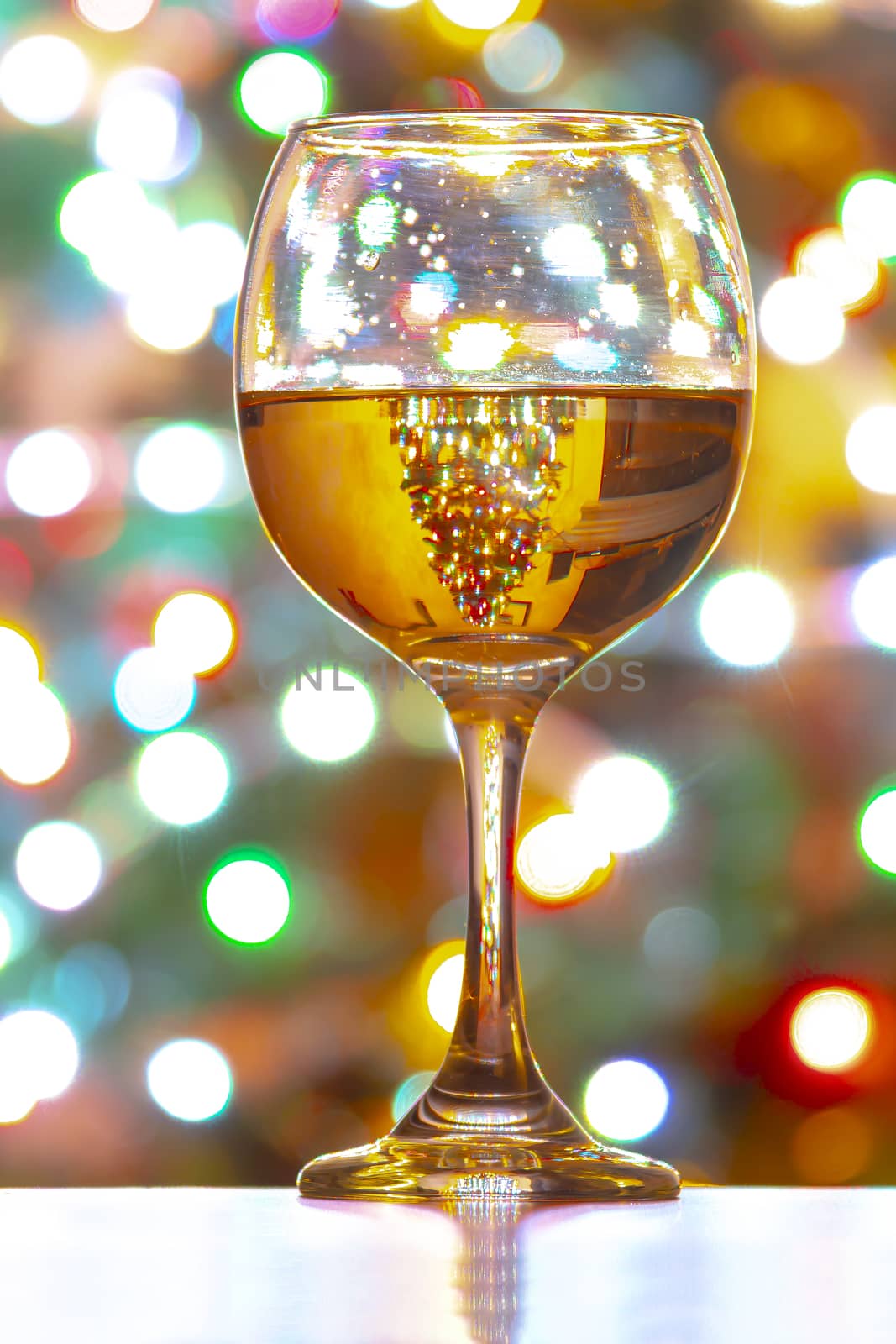 A cup of a white wine on a background of colorful lights by oasisamuel
