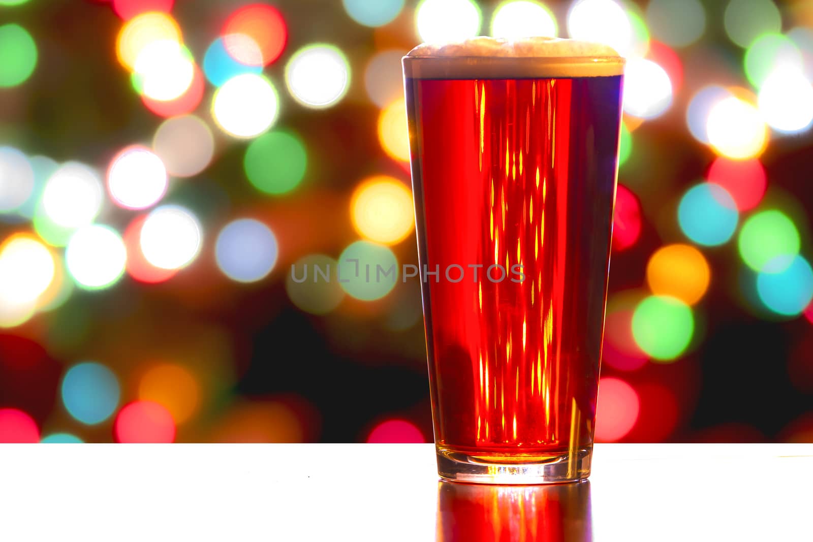 A close up of a Red Ale Beer with defocused lights in the background