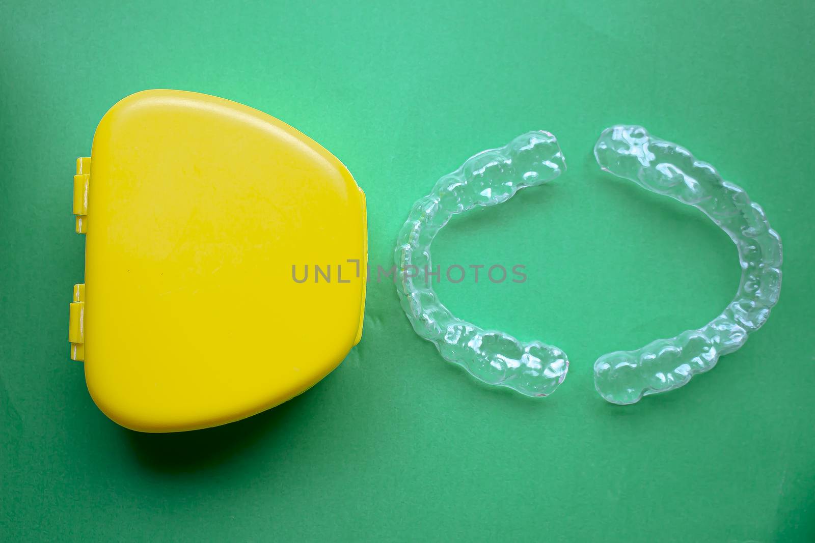 Mouth Guard with a yellow case on the right with green background