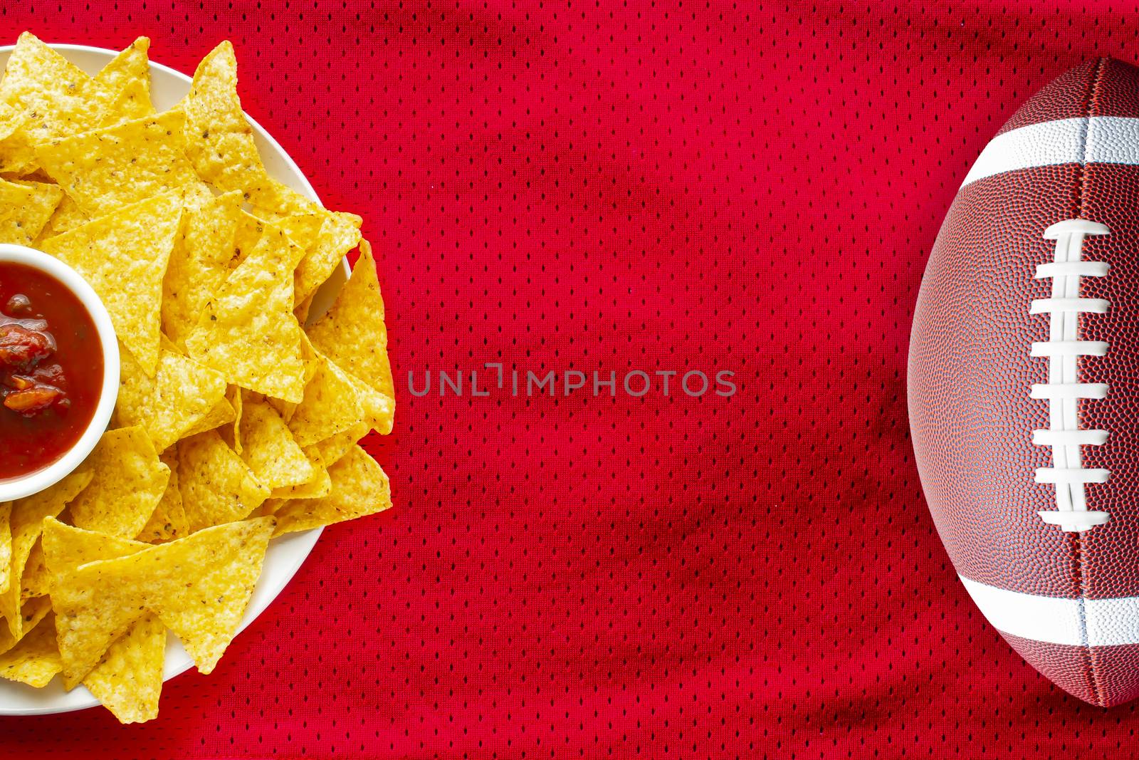 American Football Jersey textured with a football and nachos with a salsa dip on a horizontal view by oasisamuel