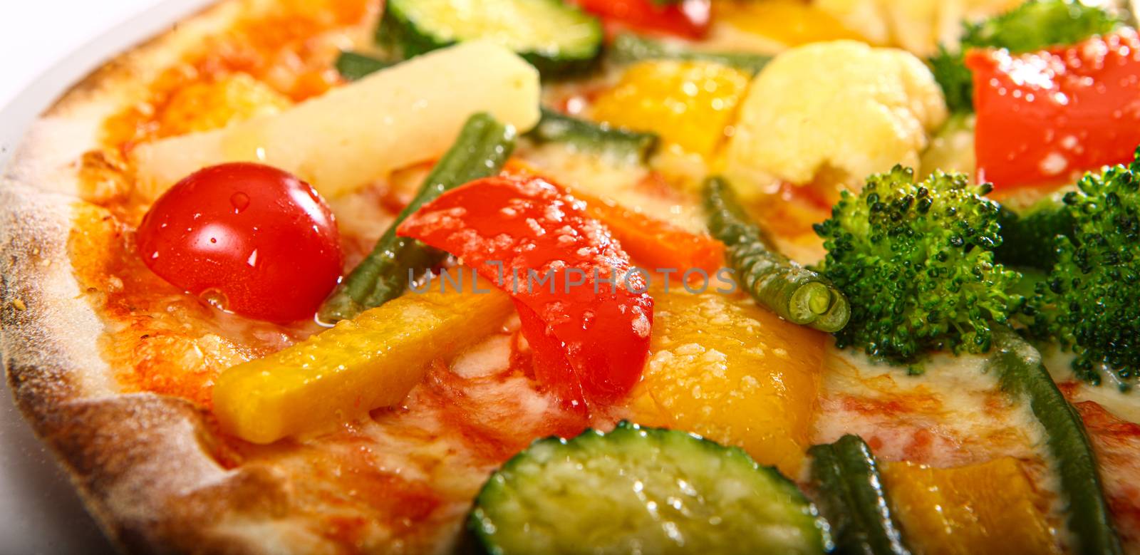 Close up of a Pizza with tomato, meat, cucumbers and pineapple and toppings