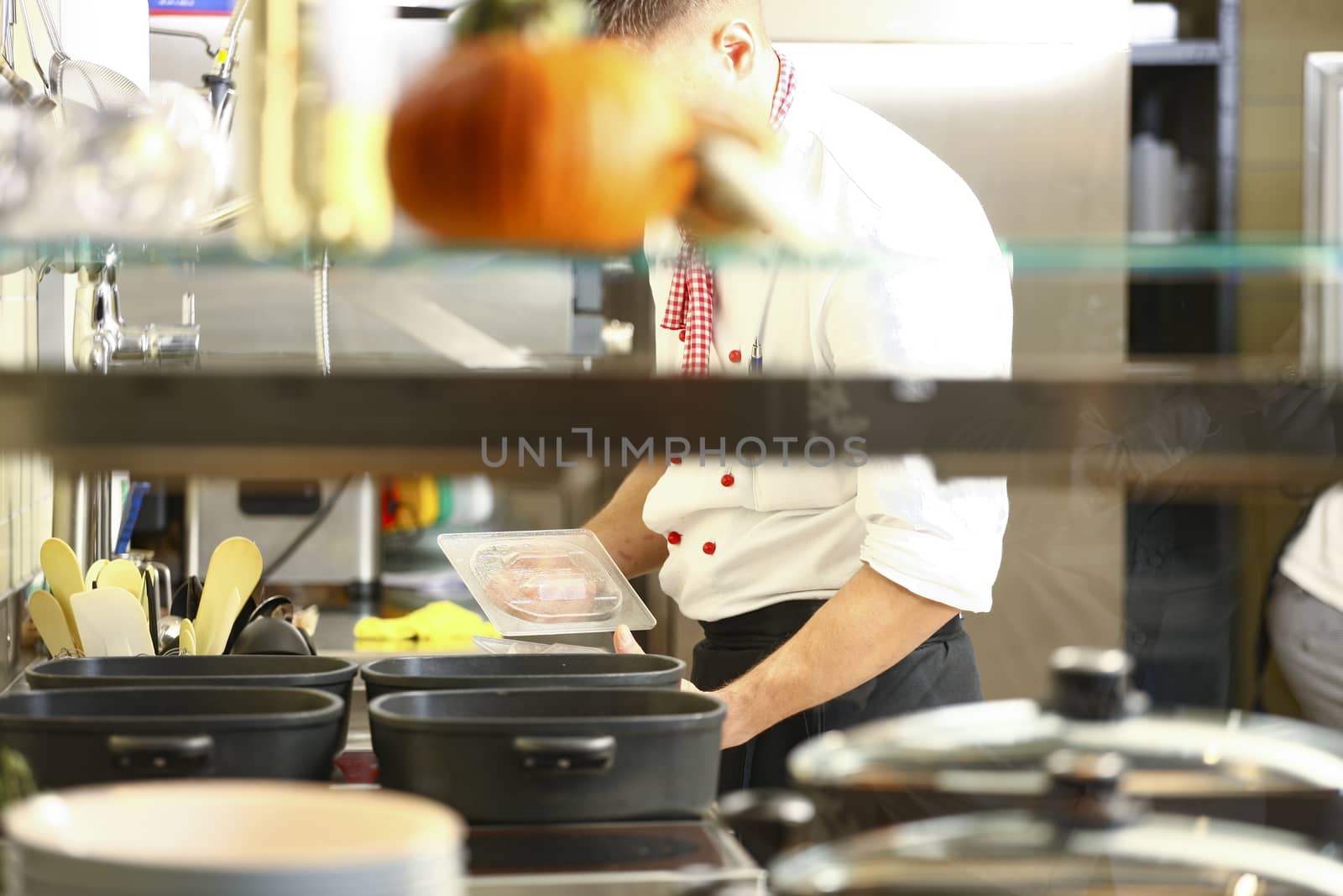 Chef is stirring and cooking rice in kitchen.. Chef cooking with cooking utensils, preparing for guests